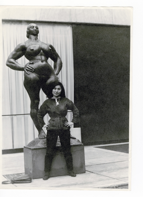 Yoko Ono with Standing Woman (1932) by Gaston Lachaise, The Museum of Modern Art Sculpture Garden, New York, c1960–61. Photograph: Minoru Niizuma. © Minoru Niizuma. Courtesy Lenono Photo Archive, New York.